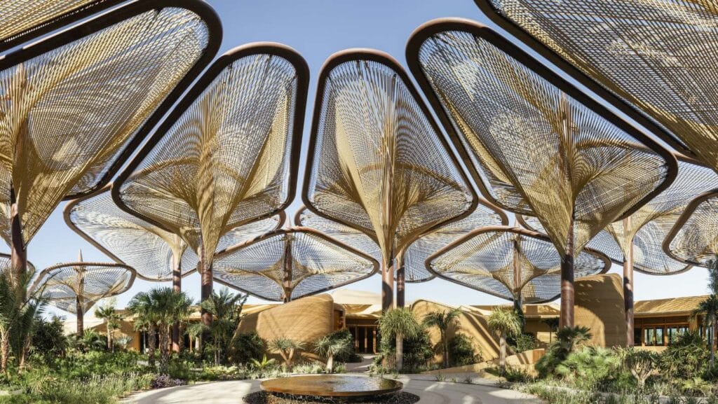 The Oasis im Six Senses Southern Dunes, The Red Sea, entfaltet sich wie eine Wüstenblume, deren Design die raue Eleganz der saudi-arabischen Wüste widerspiegelt. Sein schattenspendendes Vordach fließt nahtlos in die Landschaft über, wobei es im Innen- wie im Außenbereich natürliche Materialien mit der lokalen Flora und kunstvoll gestalteten Wasserläufen vereint