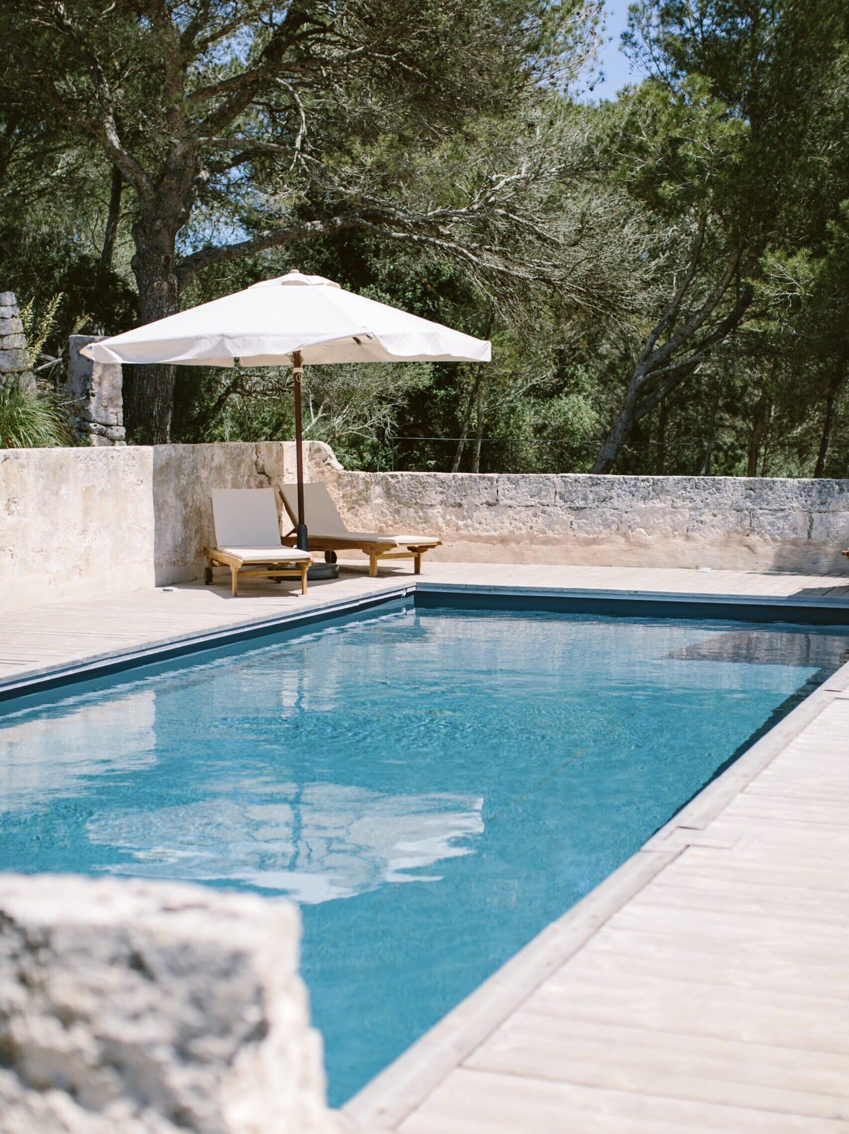 Privater Pool mit Sonnenliege und Sonnenschirm umgeben von historischen Natursteinmauern und mediterraner Vegetation im Chōju Retreat