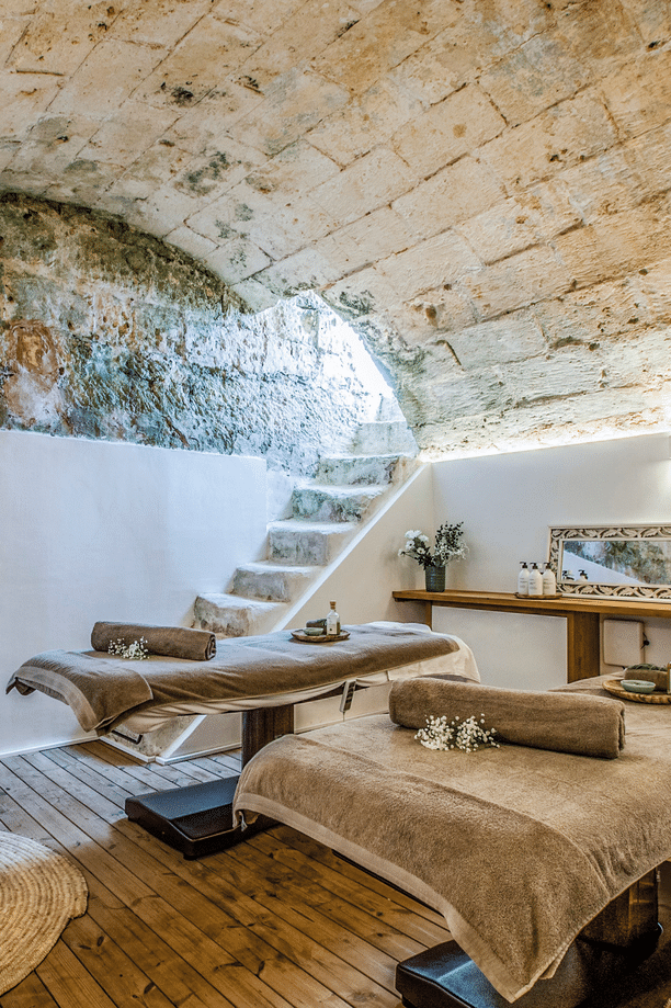 Zwei Massageliegen in historischem Gewölberaum mit originalen Natursteinwänden und Fischgrätdecke im Chōju Retreat Menorca