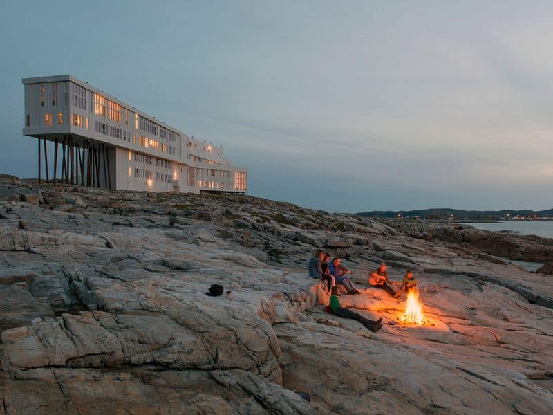 Fogo Island Inn Neufundland Gäste am Lagerfeuer auf Felsen bei Abenddämmerung Luxushotel Kanada