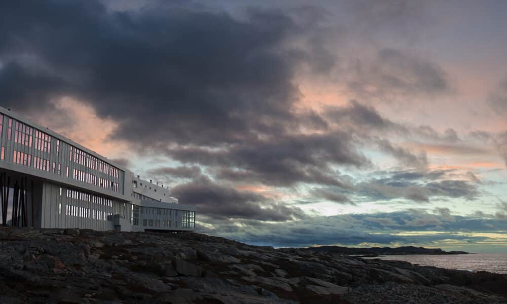 Fogo Island Inn Neufundland Luxushotel auf Felsen bei dramatischem Sonnenuntergang über dem Atlantik