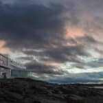 Fogo Island Inn Neufundland Luxushotel auf Felsen bei dramatischem Sonnenuntergang über dem Atlantik