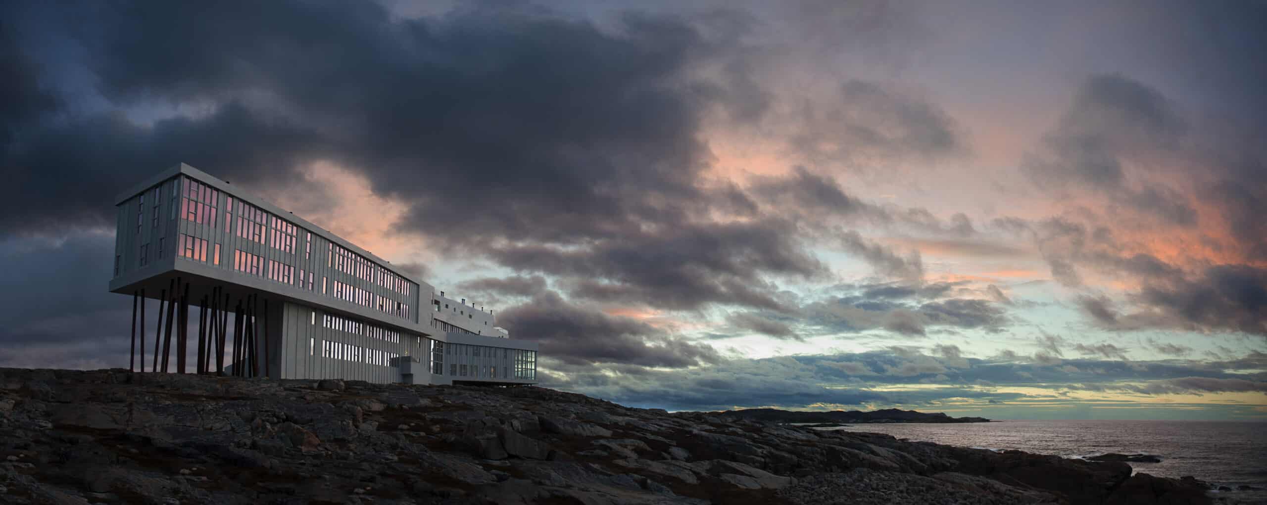 Fogo Island Inn Neufundland Luxushotel auf Felsen bei dramatischem Sonnenuntergang über dem Atlantik