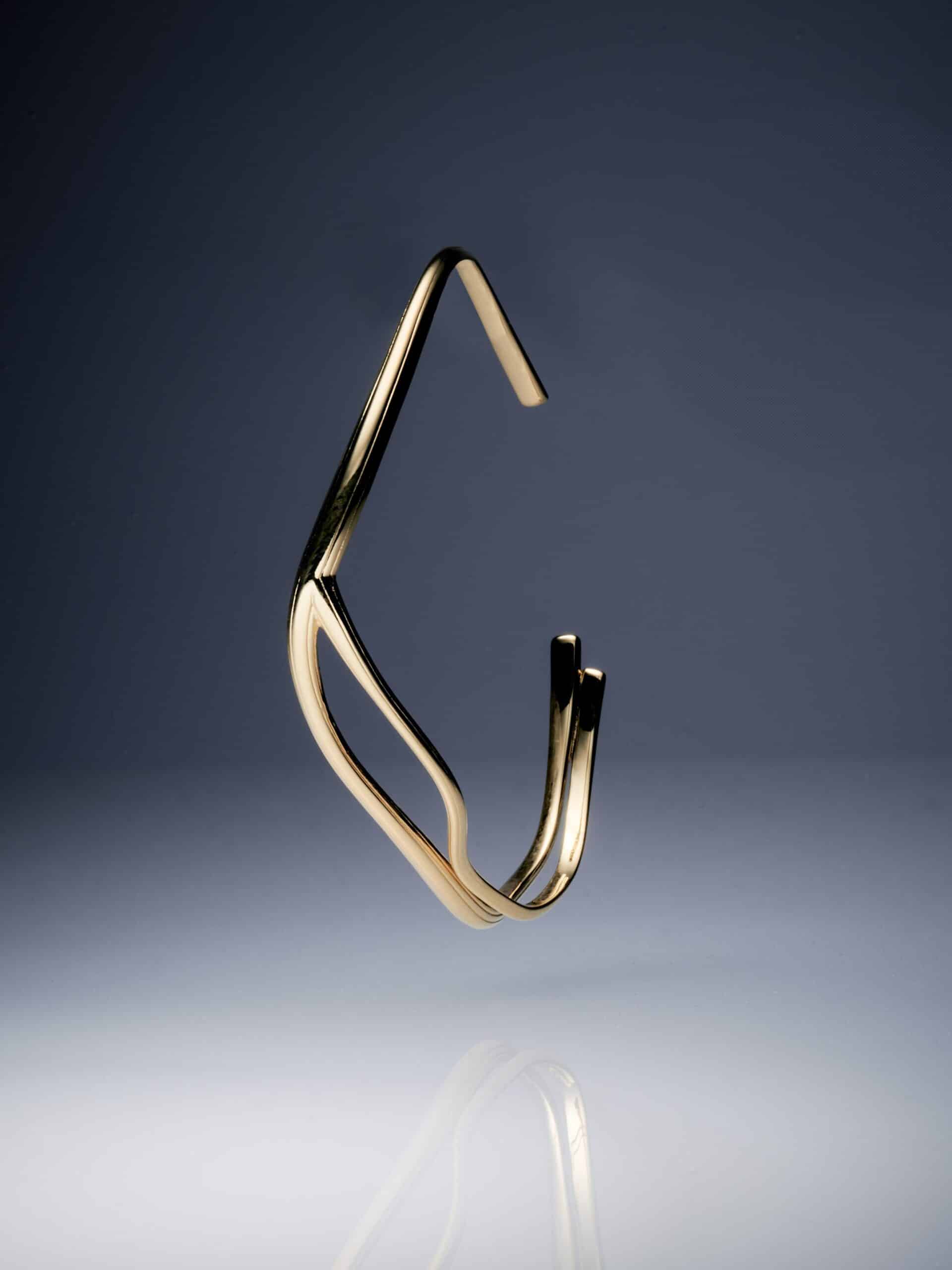 Die meisterhafte Goldschmiedekunst der Yan Jiang Fine Edition prasentiert ein schwebendes goldenes Armband, dessen fliessende Linien eine moderne Eleganz ausdrucken.