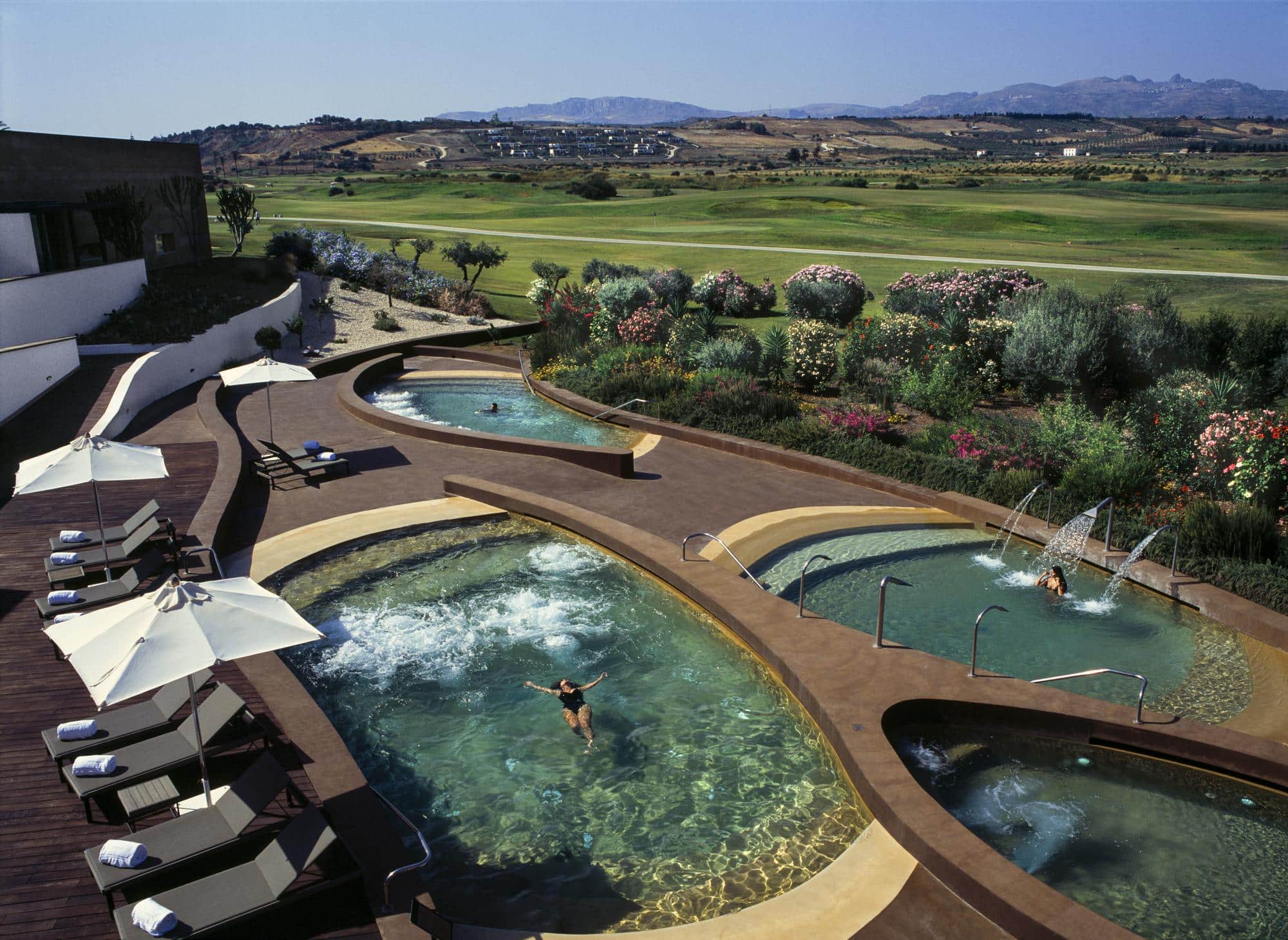 Der Experte präsentiert mit einem strahlenden Lächeln einen Teller voller Lebensfreude, der die Essenz des Blue Zone Living im Verdura Resort verkörpert.