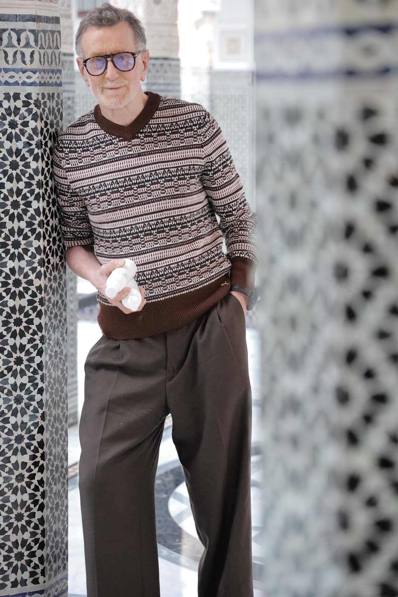 Pierre Hermé pausiert elegant inmitten der ikonischen Mosaikarbeiten des La Mamounia, wahrend er seine neuesten Kreationen prasentiert.