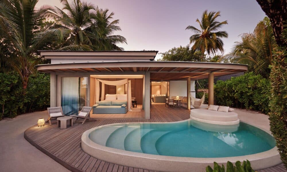 Erleben Sie einen ruhigen Abend in der Temptation Beach Pool Villa des LUX* South Ari Atoll, wo sich private Poollandschaft und elegantes Interieur unter dem rosa Abendhimmel vereinen.