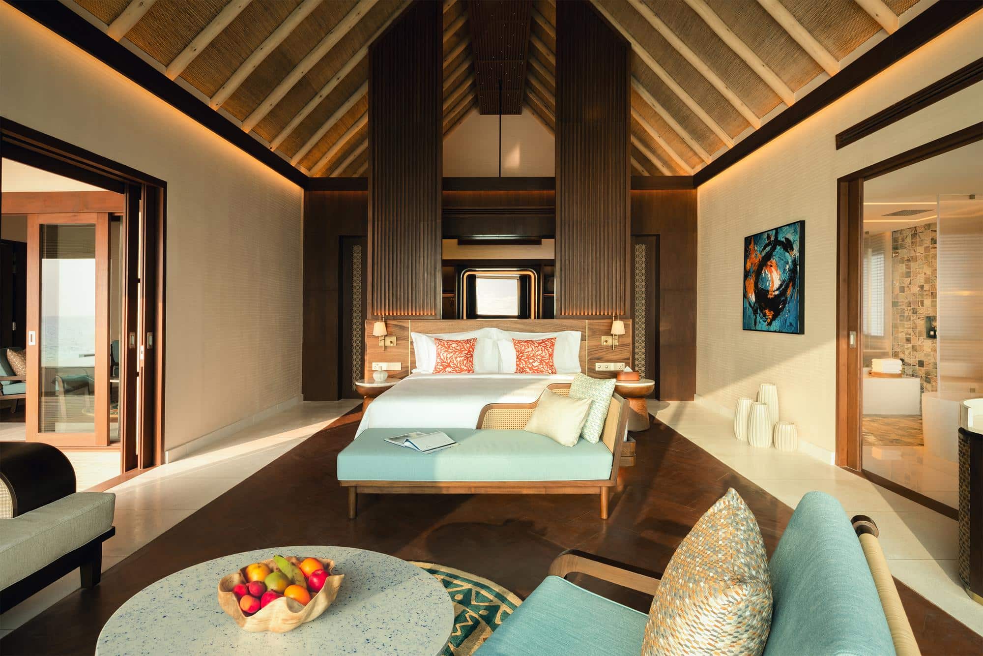 In dieser luxuriösen Boho-Villa auf den Malediven taucht die Morgensonne das geräumige Schlafzimmer in ein warmes Licht und verspricht entspannte Stunden.