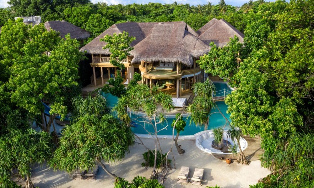 Ein atemberaubendes Hotelensemble mit Strohdachern und weitlaufigem Poolbereich fugt sich nahtlos in die grune Inselkulisse ein und definiert zukunftigen Luxus neu.